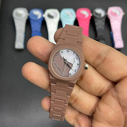 Close-up of a brown women's wrist watch featuring a marble pattern dial, silver hands, and a matching silicone strap, with multiple color variants displayed in the background.