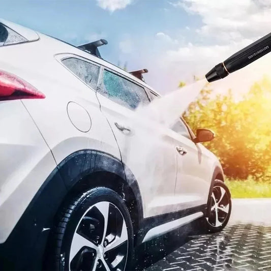 Cordless portable pressure washer spraying a powerful stream of water onto a white SUV during an outdoor car wash. High-pressure cleaning removes dirt, mud, and grime from the vehicle's surface for a spotless finish.